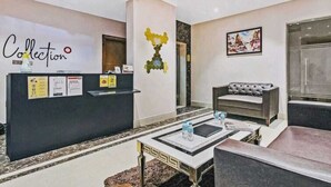 A hotel lobby with a reception desk, a sofa, and a coffee table. - Hotel Veridian (Lucknow)