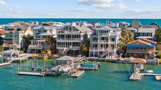 A coastal residential area with multiple houses, docks, and a marina.