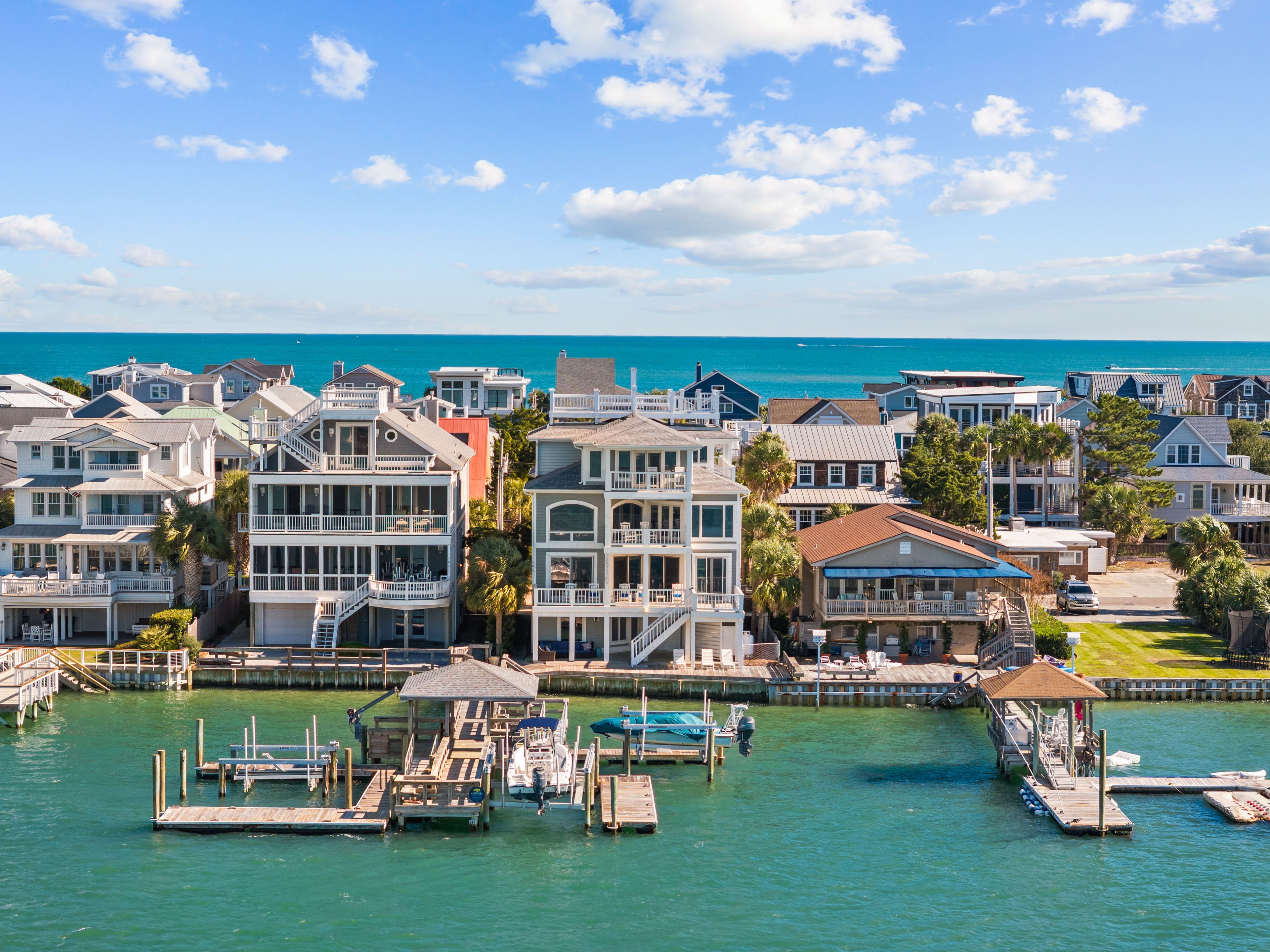 A coastal residential area with houses, docks, and a marina.