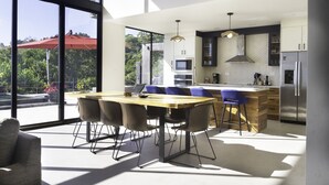 Une cuisine moderne dotée d’un grand îlot central, de tabourets de bar et d’une table à manger avec des chaises.