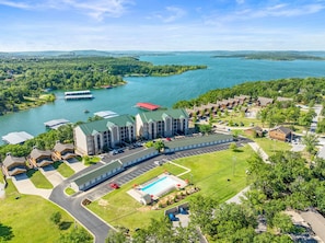 Ein Hotel mit Schwimmbad, Parkplatz und Blick auf einen See und die umliegende Natur.