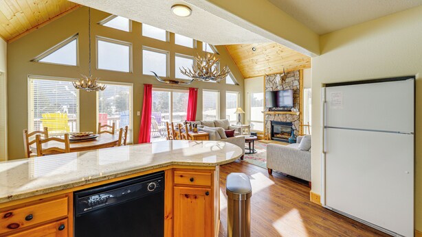 A spacious kitchen with a large island, wooden cabinetry, and a built-in dishwasher. - Mountain Home w/ Deck: 1 Mi to Angel Fire Resort! (Angel Fire)