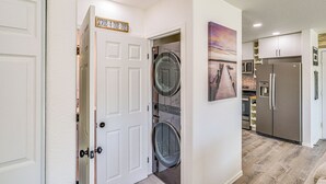 A laundry room with a door labeled "SCRUB-A-DUB" and a wall-mounted washing machine.