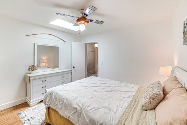 A bedroom with a bed, a dresser, a ceiling fan, and a skylight. - Family-friendly Loma Linda Retreat: Walk to LLU (Loma Linda)