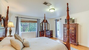 A spacious bedroom with a large bed, wooden dresser, and a mirror. - Family-friendly Loma Linda Retreat: Walk to LLU (Loma Linda)
