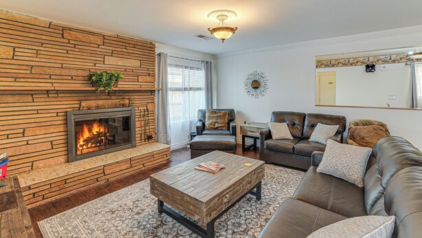 A living room with a stone fireplace, leather sofas, a coffee table, and a patterned rug. - Family-friendly Loma Linda Retreat: Walk to LLU (Loma Linda)