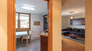A room with a dining table, chairs, a sofa, a radiator, and a cityscape painting. - Ekain - baskeyrentals (Zestoa)