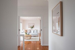 A modern living room with a sofa, coffee table, and framed artwork on the wall.