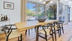 Een eethoek met een houten tafel, zes stoelen en een grote schaal.