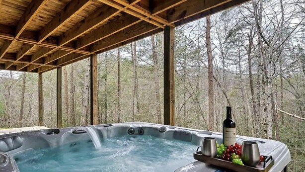 Een hottub met een houten dak, omringd door bomen.