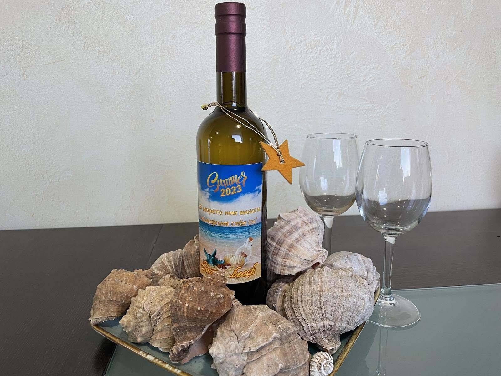 Une bouteille de vin avec une étiquette en forme d’étoile, deux verres à vin vides et une assiette remplie de coquillages.