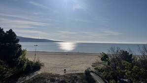A beach with a clear sky, a road leading to the beach, and a distant mountain. - Apart hotel Gallery A
Апартамент в Слънчев Бряг на първа линия-гледка море (Слънчев бряг)