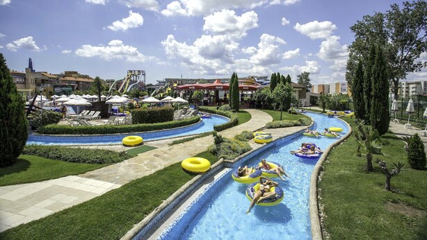A water park with multiple water slides and pools, surrounded by greenery and buildings. - Apart hotel Gallery A
Апартамент в Слънчев Бряг на първа линия-гледка море (Слънчев бряг)