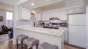 A modern kitchen with white cabinets, a granite countertop, and a built-in microwave. - 30+ Day 3BR Home One Blk off Historic Main St. Galena w/Pking and W/D (Galena)