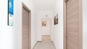 A hallway with wooden doors and a framed picture on the wall. - Large Apartment in the Center of Sorrento, close to Main Transportation Hubs. (Sorrento)