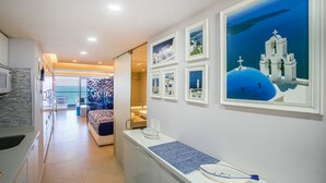 A modern hotel room with a view of the sea, a balcony, and a dining area. - 11th-Floor Oceanview Stay | Infinity Pools + Gym (Puerto Vallarta)