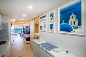 A hotel room with a view of the sea, a balcony, and a dining area with a view of the sea.