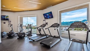 A gym with treadmills, elliptical machines, and weight benches.