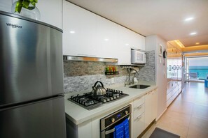 Une cuisine moderne équipée d’un réfrigérateur Whirlpool, d’une cuisinière à gaz et d’un four à micro-ondes.