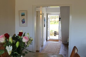 A hallway leading to a door with a view of a garden. - Sea Reach, Thurlestone, sleeps 8 (Thurlestone)