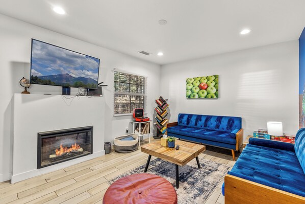 Smart TV, chimenea, libros y biblioteca musical 