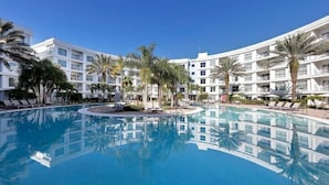 A hotel with a large pool surrounded by palm trees and lounge chairs. - "2br At Meliá Orlando Celebration #528" (Celebration)