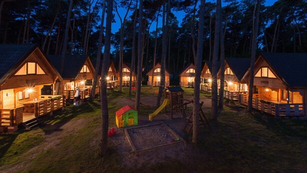 A row of wooden cabins with large windows, surrounded by tall trees. - Apartment in Pobierowo near Baltic Beach (Pobierowo)