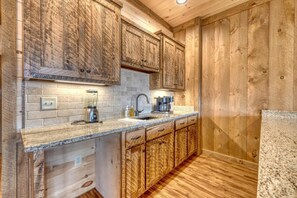 A kitchen with wooden cabinets, granite countertops, and a built-in dishwasher.