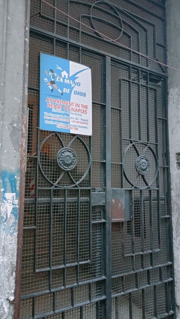 Un letrero publicita un apartamento en Nápoles con datos de contacto y servicio de transporte.