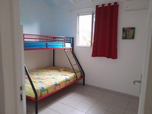 A bunk bed with a window and red curtains. - A LA Campagne : Haut DE Villa Equipee, Spacieux, Tout Confort (Lamentin)
