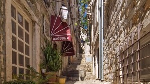 Una estrecha escalera de piedra que conduce a un edificio con un letrero que dice "RAGUSA 2".