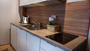 Una cocina moderna con un lavamanos de acero inoxidable, una estufa empotrada y un protector contra salpicaduras de madera.