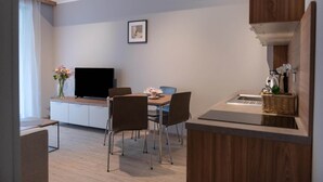 Una cocina moderna con comedor, televisor de pantalla plana y una pequeña mesa con sillas.