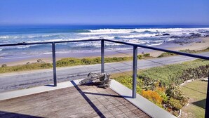 Un balcón con vista al océano y la playa.