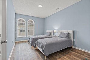 Two single beds with matching headboards and footboards, each with a nightstand and lamp in between.