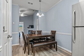 Enjoy cooking in this well-equipped kitchen with a central island, stainless steel refrigerator, and dining area.