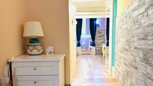 A hallway with a white dresser, a lamp, and a tiled floor. - San Cesareo Apartment (Sorrento)