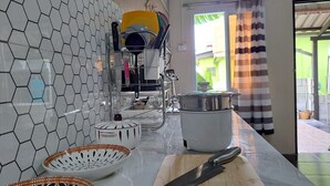 Une cuisine avec un dosseret de crédence en carreaux hexagonaux, un plan de travail en bois et une grande planche à découper.