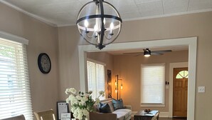 A dining area with a wooden table, chairs, and a chandelier. - Relaxing 2-bedroom cottage in beautiful Sanford  (Sanford)