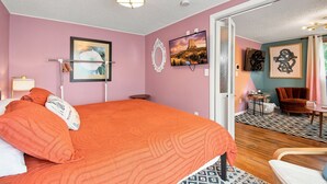 A bedroom with a bed, a bedside table, a lamp, a mirror, and a television. - ColorHouse | 1 mi to Mayo Clinic, No Stairs Entry (Rochester)