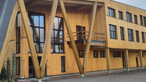 A modern building with a wooden facade, large windows, and a prominent metal structure. - Cosy cottage in quiet surroundings in the southern Norwegian mountains (Bortelid)