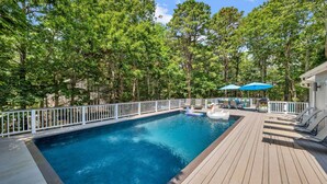 A wooden deck with a swimming pool, surrounded by trees and a white fence. - Beautiful East Hampton Home, Expansive Deck, Private Pool, Indoor/Outdoor... (East Hampton)