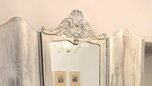 A vintage-style wardrobe with ornate carvings and brass handles. - Appartamento Simona Comfort&relax in Centro Paese (Castiglione dei Pepoli)
