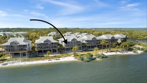 Un hotel frente al mar con varias edificaciones, una playa y una extensión de agua.