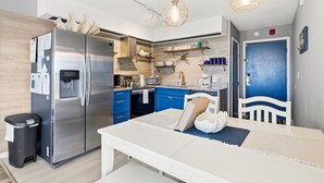 Una cocina compacta con un refrigerador de acero inoxidable, un microondas y una cafetera.