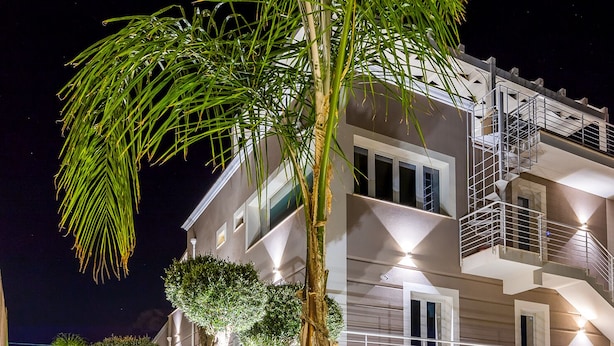 Un edificio de varios pisos con un diseño moderno, con balcones y una escalera.