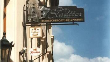 A building with a sign for 'Zum Stadttor' indicating a historical restaurant and pension.