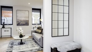 Un saló modern amb un sofà, una taula de centre i una orquídia decorativa.