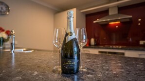Una bottiglia di champagne Lindauer Special Reserve Blanc de Blancs su un piano di lavoro della cucina, con due bicchieri.