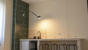 Cocina moderna con área de taburetes, una pequeña mesa y una lámpara colgante.